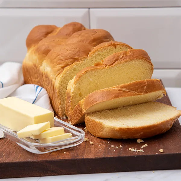 a loaf of bread with butter on a cutting board