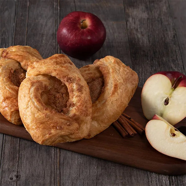 group of pastries and apples on a wooden board