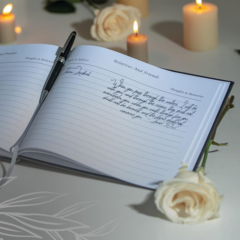 notebook with a pen and roses and candles on a table