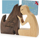 wooden figurine of a person kissing a dog 