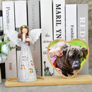 angel figurine holding a dog statue and photo frame of a dog and child