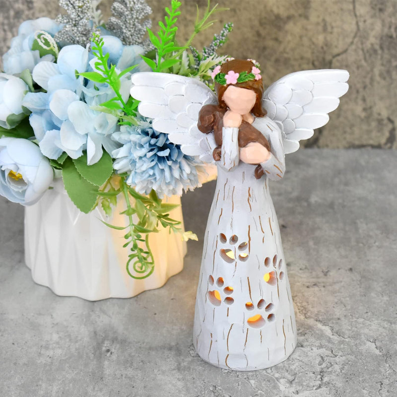 white angel figurine next to a vase of flowers
