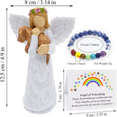 angel figurine holding a dog and a bracelet and a card